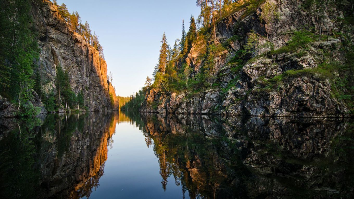 kesäkuva, tyyni vesi, molemmin puolin jyrkät kalliot.