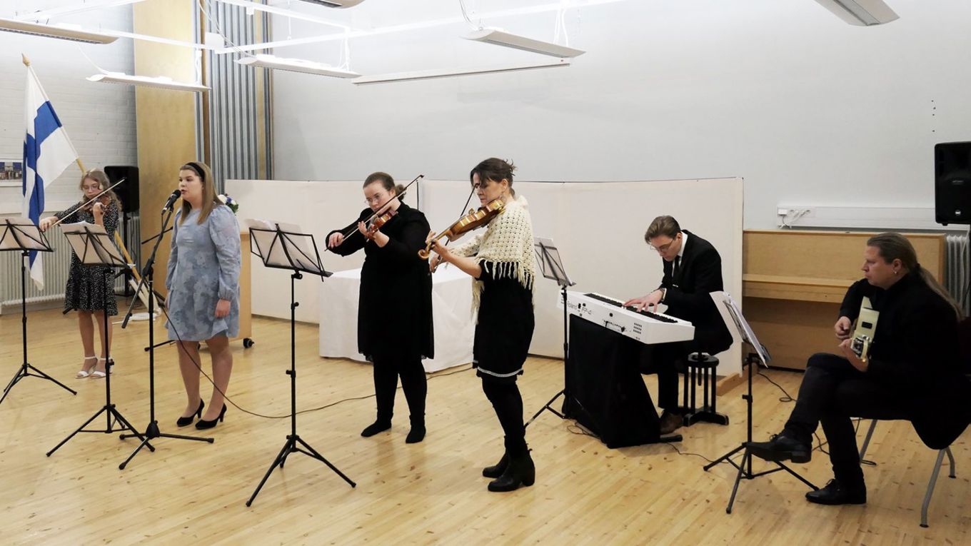 Esiintymässä neljä viulunsoittajaa, pianisti ja kitaristi.