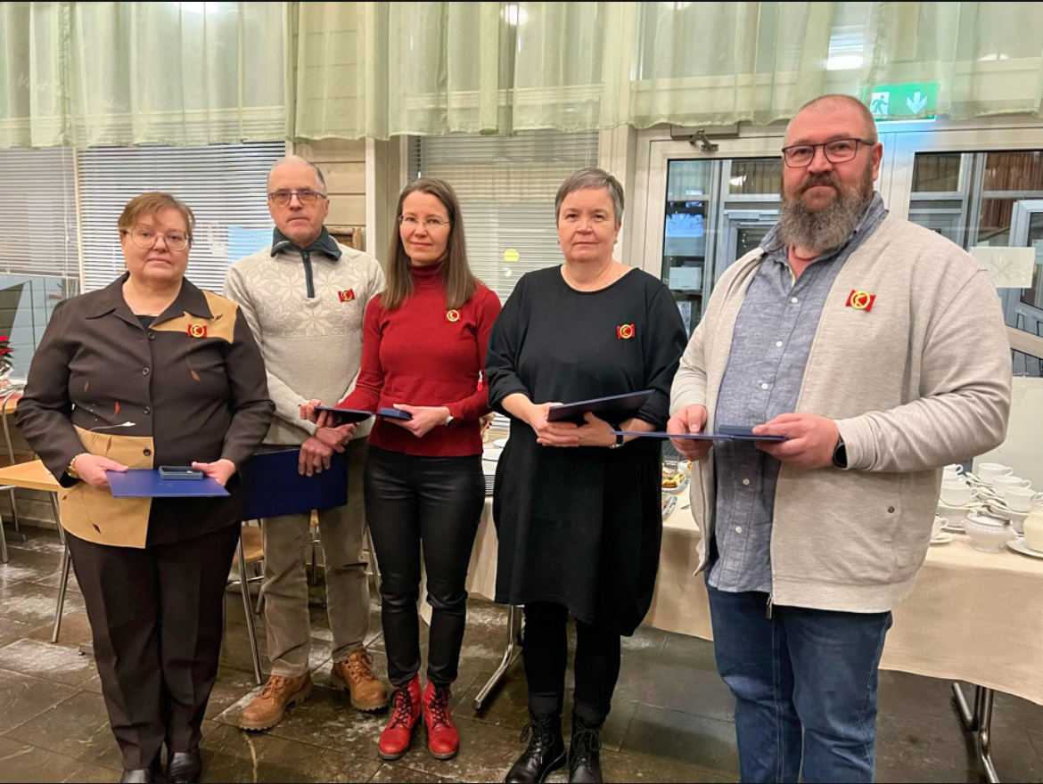 5 henkilöä seisoo ja heillä käsissä diplomit