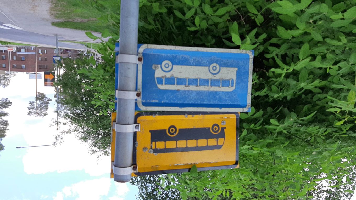 Kuvituskuvassa linja-autopysäkin lähi- ja kaukoliikenteenkyltit, kesällä otettu kuva.